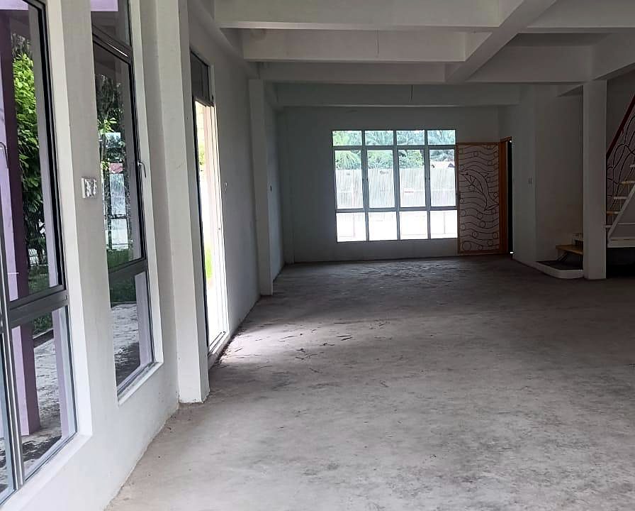 Ruang tamu lapang dengan tingkap kaca setinggi dinding dan cahaya semula jadi.